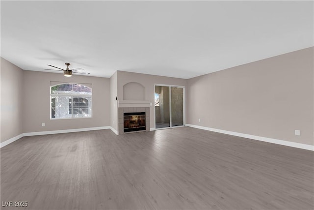 4324 W Lake Mead Blvd Unit 202, Las Vegas, NV 89108 - unfurnished living room featuring wood finished floors, a ceiling fan, a tile fireplace, and baseboards