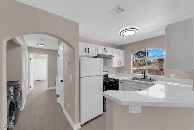 4324 W Lake Mead Blvd Unit 202, Las Vegas, NV 89108 - kitchen featuring separate washer and dryer, freestanding refrigerator, gas range oven, under cabinet range hood, and arched walkways