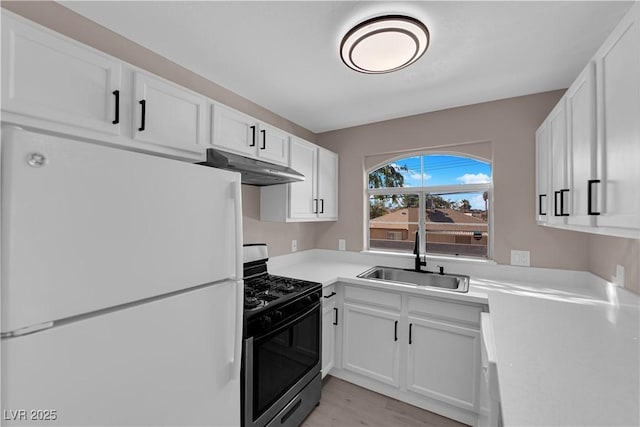 4324 W Lake Mead Blvd Unit 202, Las Vegas, NV 89108 - kitchen with freestanding refrigerator, stainless steel range with gas cooktop, a sink, under cabinet range hood, and white cabinetry