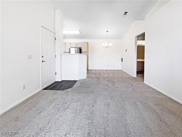 unfurnished living room featuring a chandelier, carpet, vaulted ceiling, and baseboards