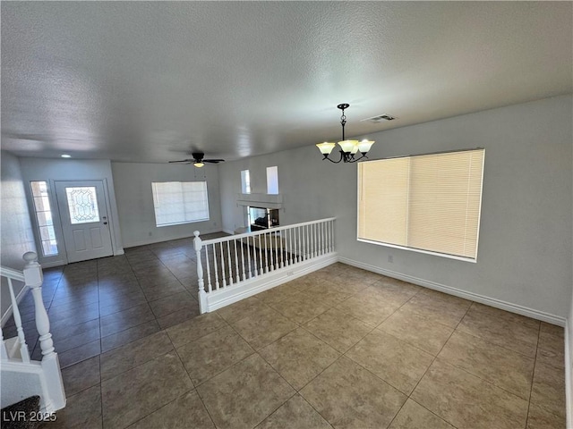 10574 Salmon Leap St, Las Vegas, NV 89183 - tiled empty room featuring a textured ceiling, a chandelier, baseboards, and a ceiling fan