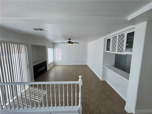 10574 Salmon Leap St, Las Vegas, NV 89183 - unfurnished living room with a textured ceiling, ceiling fan, tile patterned flooring, and baseboards