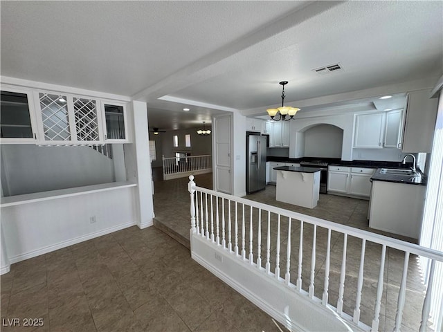 10574 Salmon Leap St, Las Vegas, NV 89183 - kitchen with stainless steel refrigerator with ice dispenser, a chandelier, a center island, a sink, and dark countertops