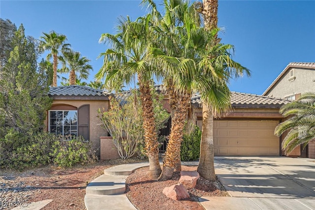 10310 Songsparrow Ct, Las Vegas, NV 89135 - mediterranean / spanish house featuring a tile roof, stucco siding, a garage, and concrete driveway