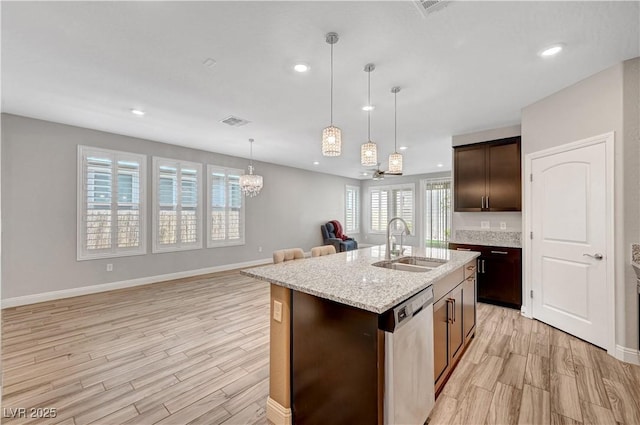 kitchen with stainless steel dishwasher, a sink, light wood-style floors, dark brown cabinets, and recessed lighting