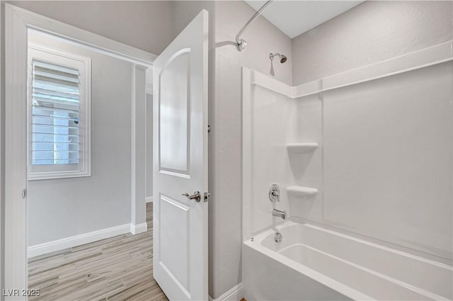 full bath with shower / washtub combination, baseboards, and wood finished floors