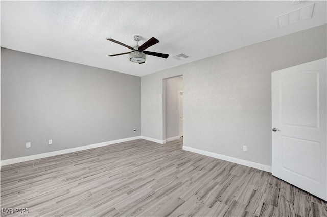 unfurnished room featuring a ceiling fan, light wood-style floors, and baseboards