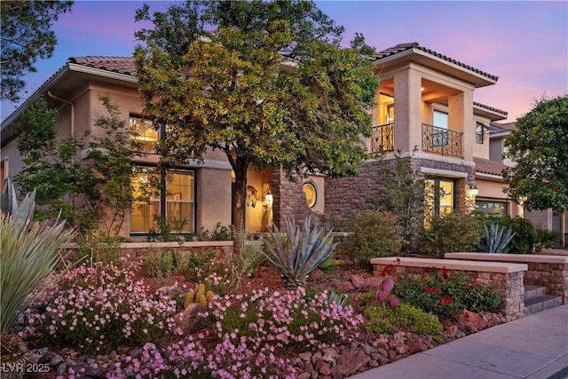 3010 Hammerwood Dr, Las Vegas, NV 89135 - view of front facade featuring a balcony, a tile roof, stucco siding, and stone siding