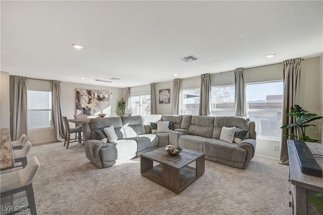 carpeted living area with plenty of natural light, baseboards, and recessed lighting