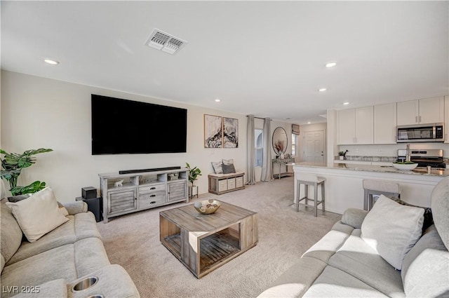 living room featuring light carpet and recessed lighting