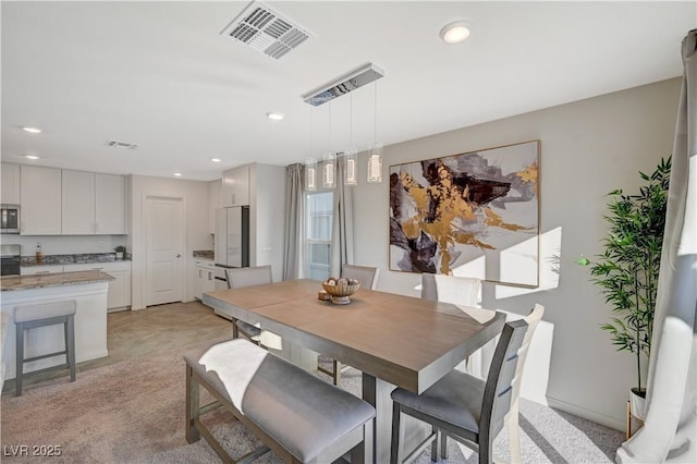 dining room with recessed lighting and light carpet