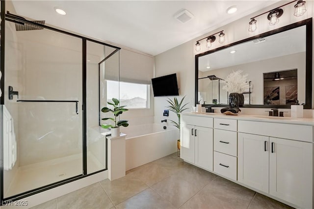bathroom with a stall shower, double vanity, a garden tub, and tile patterned floors