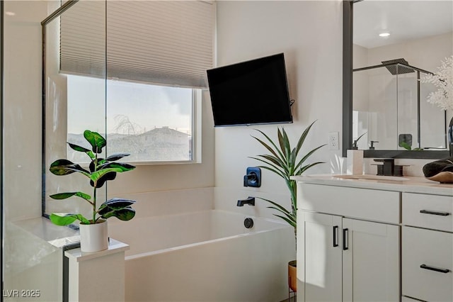 full bathroom with a garden tub and vanity