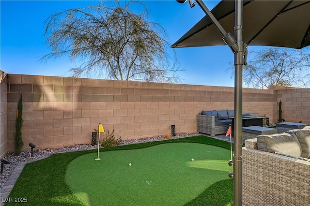 fenced backyard with a putting green and an outdoor hangout area