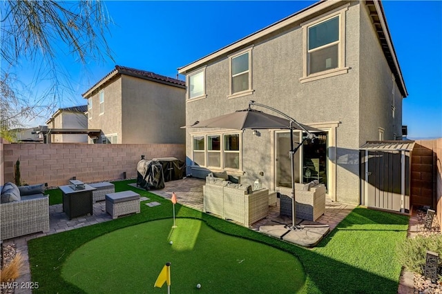 back of property with an outdoor hangout area, stucco siding, a putting area, and a patio area