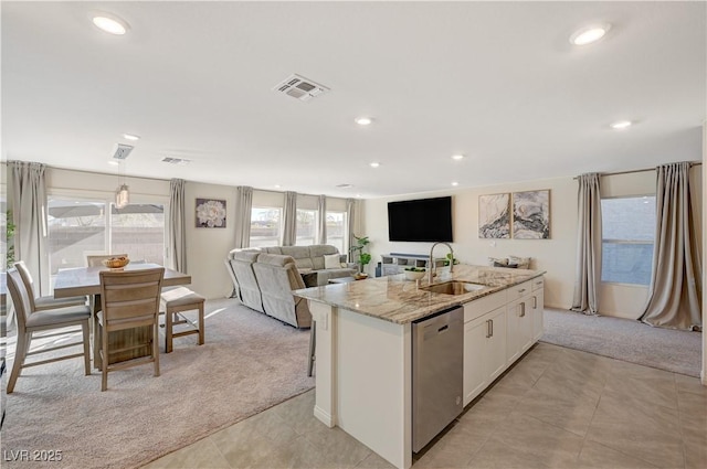 kitchen featuring a sink, stainless steel dishwasher, light colored carpet, white cabinets, and recessed lighting
