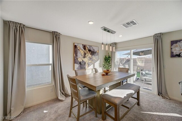 dining space with light colored carpet and baseboards