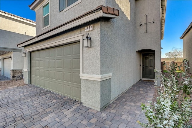 garage with decorative driveway