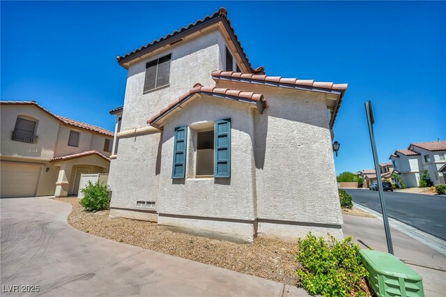 9165 Starling Wing Pl, Las Vegas, NV 89143 - view of property exterior with a tiled roof, stucco siding, and driveway