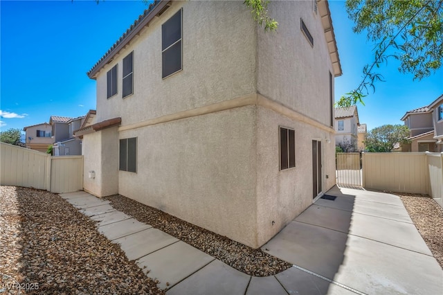 9165 Starling Wing Pl, Las Vegas, NV 89143 - view of side of property featuring stucco siding, a patio, and a tiled roof