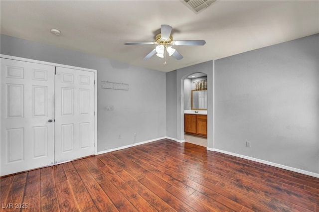 9165 Starling Wing Pl, Las Vegas, NV 89143 - unfurnished bedroom with arched walkways, hardwood / wood-style flooring, and baseboards