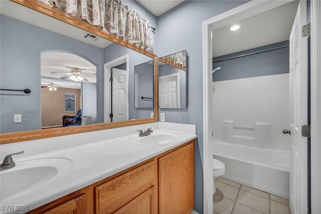 9165 Starling Wing Pl, Las Vegas, NV 89143 - bathroom featuring a ceiling fan, toilet, double vanity, tile patterned floors, and  shower combination