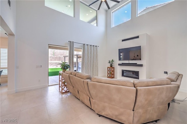 201 Carmel Sky St, Las Vegas, NV 89138 - living area featuring a towering ceiling, a ceiling fan, a glass covered fireplace, and light tile patterned flooring