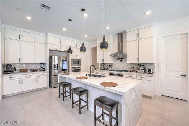 201 Carmel Sky St, Las Vegas, NV 89138 - kitchen with wall chimney range hood, stainless steel appliances, decorative backsplash, white cabinetry, and recessed lighting
