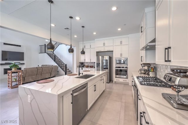 201 Carmel Sky St, Las Vegas, NV 89138 - kitchen featuring stainless steel appliances, tasteful backsplash, white cabinetry, exhaust hood, and hanging light fixtures
