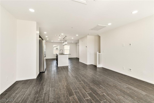 unfurnished living room featuring dark wood-style floors, recessed lighting, and baseboards