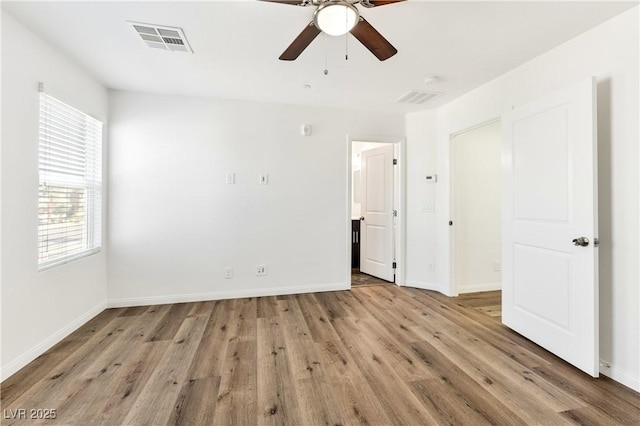 unfurnished bedroom featuring light wood-style flooring, baseboards, and a ceiling fan