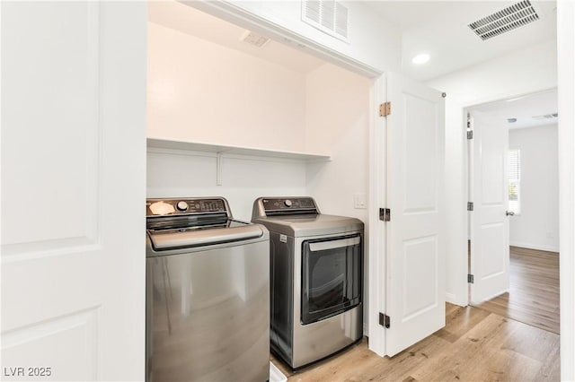 laundry room featuring washer and clothes dryer, light wood finished floors, and recessed lighting