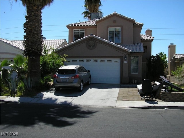 1927 Raspberry Hill Rd, Las Vegas, NV 89142 - mediterranean / spanish-style house with driveway, stucco siding, a tile roof, and an attached garage