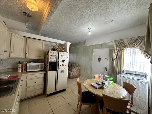 2300 Pardee Pl, Las Vegas, NV 89104 - kitchen with white appliances, a sink, light tile patterned floors, light countertops, and a textured ceiling