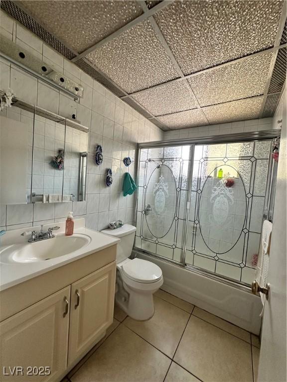 2300 Pardee Pl, Las Vegas, NV 89104 - full bathroom featuring shower / bath combination with glass door, tile walls, vanity, toilet, and tile patterned floors
