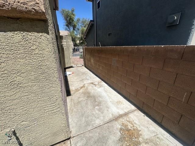 view of property exterior featuring fence, a gate, and stucco siding