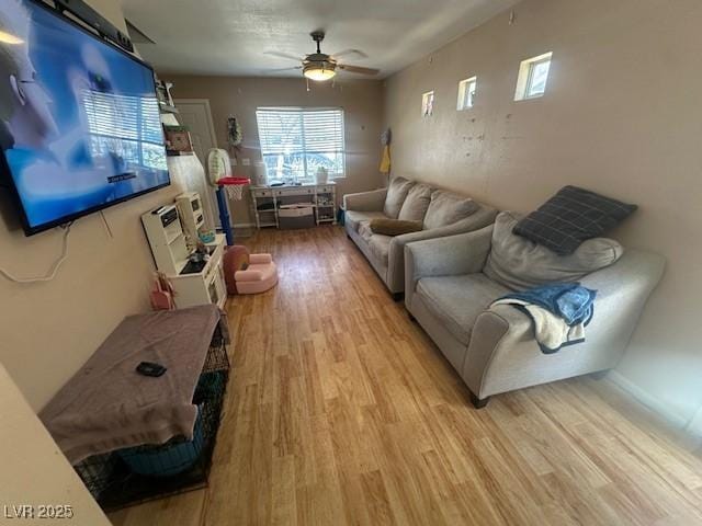 living area featuring light wood-style floors and ceiling fan