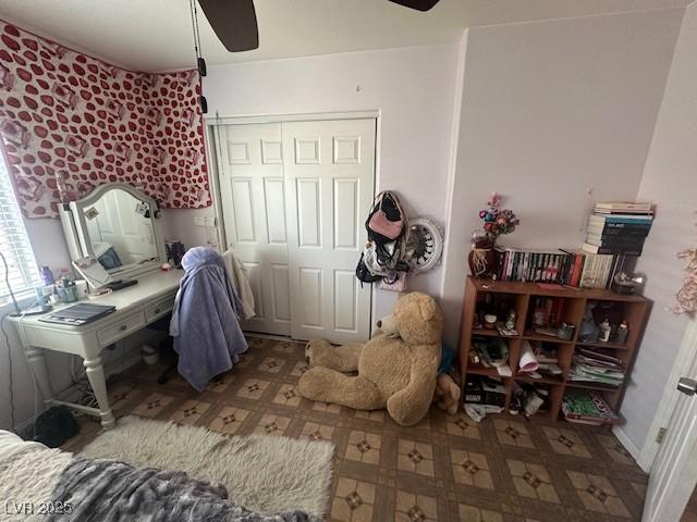 bedroom featuring tile patterned floors, a closet, and a ceiling fan