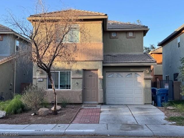 traditional home featuring an attached garage, driveway, and stucco siding