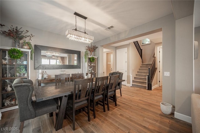 3698 Regatta Landing Dr, Las Vegas, NV 89141 - dining space featuring stairway, a chandelier, wood finished floors, and baseboards
