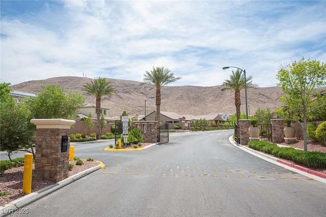 3698 Regatta Landing Dr, Las Vegas, NV 89141 - view of asphalt street featuring curbs, street lighting, a gated entry, a mountain view, and a residential view