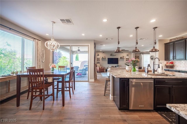 3698 Regatta Landing Dr, Las Vegas, NV 89141 - kitchen with a sink, ceiling fan, open floor plan, a chandelier, and light stone counters