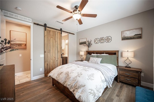 3698 Regatta Landing Dr, Las Vegas, NV 89141 - bedroom featuring a barn door, dark wood finished floors, baseboards, and ceiling fan