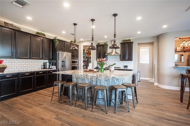 3698 Regatta Landing Dr, Las Vegas, NV 89141 - kitchen featuring a breakfast bar, backsplash, light stone counters, and recessed lighting