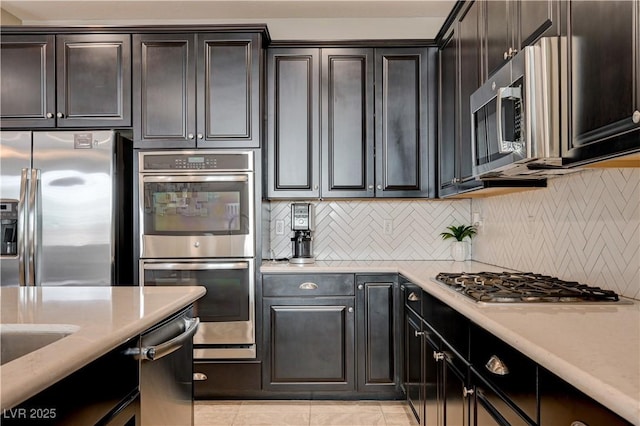 kitchen featuring appliances with stainless steel finishes, backsplash, and light tile patterned floors