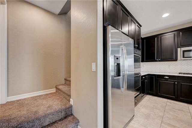 kitchen with appliances with stainless steel finishes, decorative backsplash, light countertops, dark cabinets, and recessed lighting