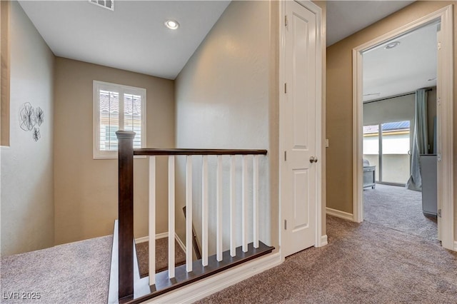 corridor featuring carpet floors, an upstairs landing, recessed lighting, and baseboards