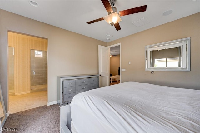 carpeted bedroom with multiple windows, ensuite bath, ceiling fan, and baseboards