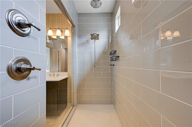 full bath with a tile shower and vanity