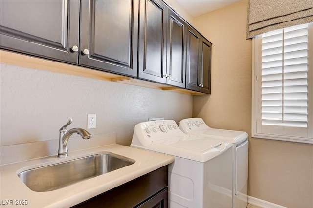 clothes washing area with washing machine and dryer and cabinet space